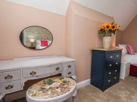 A bedroom with a mirror, table, and flowers at Lansdowne Grange in Bridlington