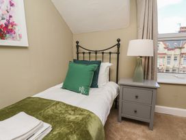 A bedroom with a single bed and nightstand at Lansdowne Grange in Bridlington