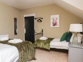 A bedroom with two beds and a bedside table at Lansdowne Grange in Bridlington