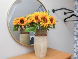 A vase with sunflowers next to a mirror in a room at Lansdowne Grange Bridlington