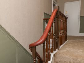 A staircase with wooden handrail and door at Lansdowne Grange in Bridlington