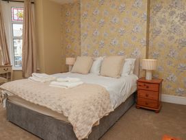 A bedroom with a bed and a wooden table at Lansdowne Grange in Bridlington