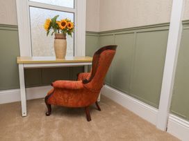 A room with a table and flowers in a vase at Lansdowne Grange in Bridlington