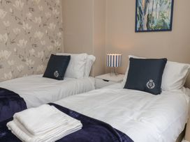 A bedroom with two beds and a nightstand at Lansdowne Grange Bridlington