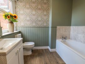 A bathroom with a bathtub and sink at Lansdowne Grange in Bridlington