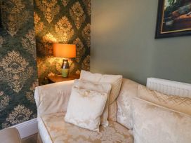 A living room with a sofa and lamp at Lansdowne Grange in Bridlington