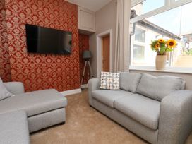 A living room with a sofa and tv at Lansdowne Grange in Bridlington