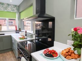 A kitchen with a sink, oven, and bowl of fruits at Lansdowne Grange in Bridlington