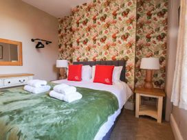 A bedroom with a bed and decorative wallpaper at Lansdowne Grange in Bridlington