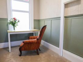 A study with a chair and table in front of a window at Lansdowne Grange in Bridlington