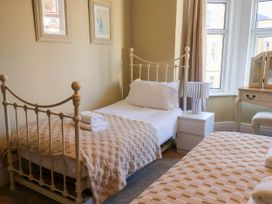 A bedroom with two beds and a bedside table at Lansdowne Grange in Bridlington