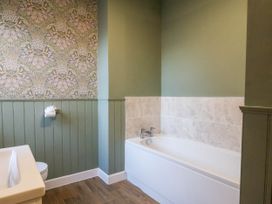 A bathroom with a bathtub and toilet at Lansdowne Grange in Bridlington