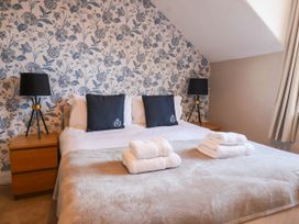 A bedroom with a bed, pillows, lamp, and towels at Lansdowne Grange in Bridlington