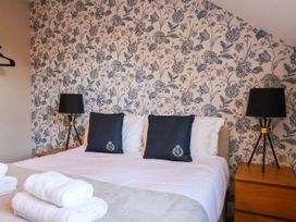 A bedroom with a double bed and decorative wallpaper at Lansdowne Grange in Bridlington