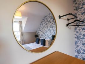 A bedroom with a mirror and bed at Lansdowne Grange in Bridlington