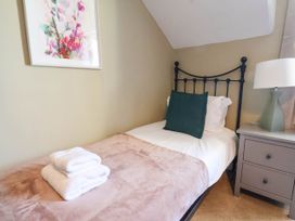 A bedroom with a bed, towels and a lamp at Lansdowne Grange in Bridlington