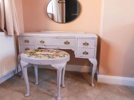 A vanity table with a mirror and a stool at Lansdowne Grange in Bridlington