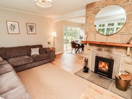 A living room with a sofa and fireplace at Hedley Dene Cottage in Longhorsley