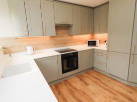 A kitchen with cabinets and appliances at Hedley Dene Cottage in Longhorsley