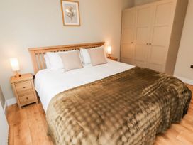 A bedroom with a bed and bedside table at Hedley Dene Cottage in Longhorsley