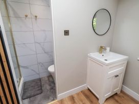 A bathroom with a shower, toilet, and sink at Hedley Dene Cottage Longhorsley