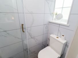 A bathroom with a toilet and shower at Hedley Dene Cottage Longhorsley