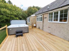 An outdoor deck with a hot tub at Hedley Dene Cottage in Longhorsley