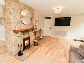 A living room with a fireplace and TV at Hedley Dene Cottage Longhorsley