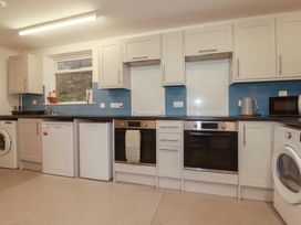 A kitchen with appliances including a washing machine and oven at Newseal House