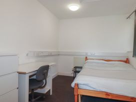 A bedroom with a bed, desk and chair at Newseal House