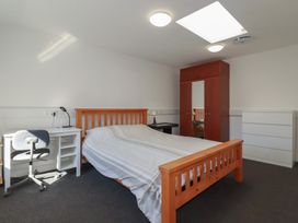 A bedroom with a bed, desk, chair, and wardrobe at Newseal House