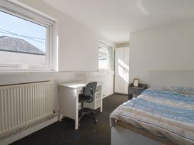 A bedroom with a bed, desk, and wardrobe at Newseal House