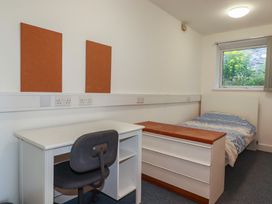 A bedroom with a bed and desk at Newseal House