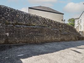 An outdoor area with a stone wall and gravel surface at Newseal House