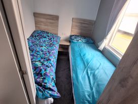A bedroom with two single beds and a window at Haven Seashore, Ellerton Willerby Xtra, Great Yarmouth