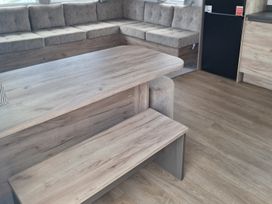 A living room with a sofa and a dining table at Haven Seashore, Ellerton Willerby Xtra, Great Yarmouth