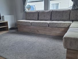 A living room with a sofa and television at Haven Seashore, Ellerton Willerby Xtra in Great Yarmouth