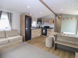 A kitchen with appliances and seating at Haven Seashore, Ellerton Willerby Xtra, Great Yarmouth