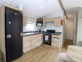 A kitchen with appliances and storage at Haven Seashore, Ellerton Willerby Xtra Great Yarmouth