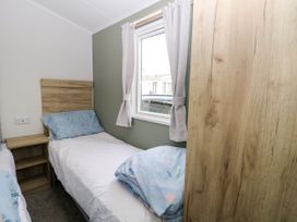 A bedroom with two single beds and a window at Haven Seashore, Ellerton Willerby Xtra, Great Yarmouth