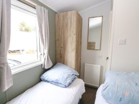 A bedroom with two beds and a wardrobe at Haven Seashore, Ellerton Willerby Xtra in Great Yarmouth