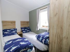 A bedroom with two single beds and a window at Haven Seashore, Ellerton Willerby Xtra, Great Yarmouth
