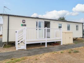 A caravan with a deck and storage shed at Haven Seashore, Ellerton Willerby Xtra, Great Yarmouth