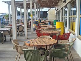 A restaurant patio with wooden tables and colorful chairs at Haven Seashore, Ellerton Willerby Xtra, Great Yarmouth
