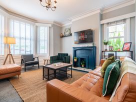 A living room with a sofa, chair, television, and coffee table at 59 Garfield Road in Scarborough