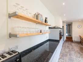 A kitchen with shelves holding glasses and mugs at 59 Garfield Road, Scarborough