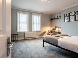 A bedroom with a bed, desk, and windows at 59 Garfield Road in Scarborough