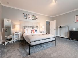 A bedroom with a bed, bedside table, lamp and wardrobe at 59 Garfield Road Scarborough