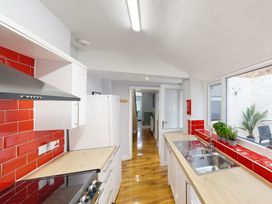 A kitchen with white cabinets and red tile at 44 Norwood Street Scarborough
