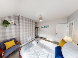 A bedroom with a bed a sofa and artwork at 44 Norwood Street Scarborough